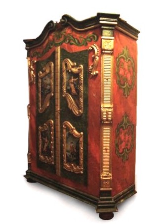 Read more about the article Bauernschrank orange golden – reich bemalt mit Putten-Aufsatz